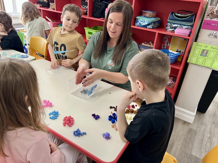 Des enfants dans une garderie jouent à des jeux avec Naomie Pelletier.