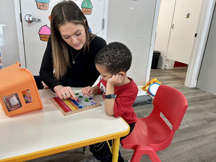 Une éducatrice et un enfant apprennent les bases des chiffres.