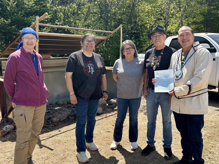 Jonathan Shetush est en compagnie de gens à l'extérieur et tient une lettre dans ses mains.
