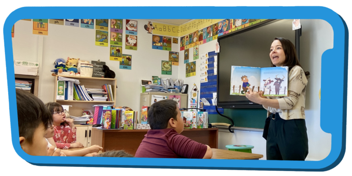 Une personne montre un livre à des enfants dans une classe.