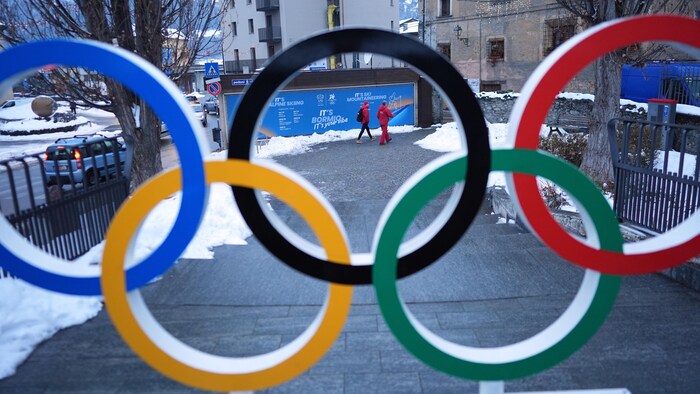 Des gens marchent, une prise de vue à l'intérieur des anneaux olympiques.