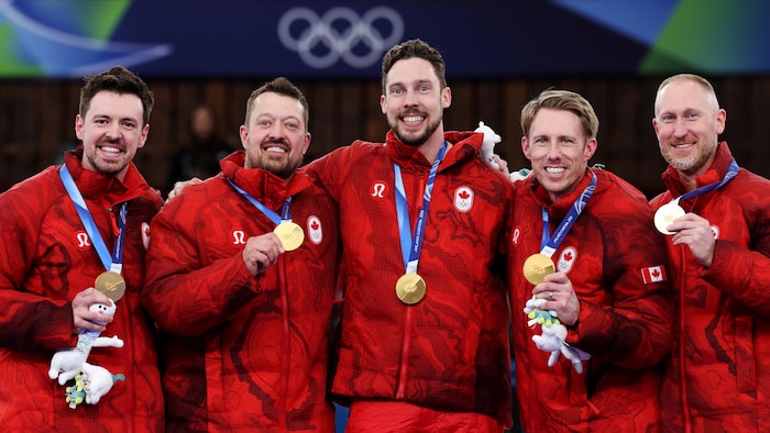 Cinq athlètes avec leurs médailles d'or.