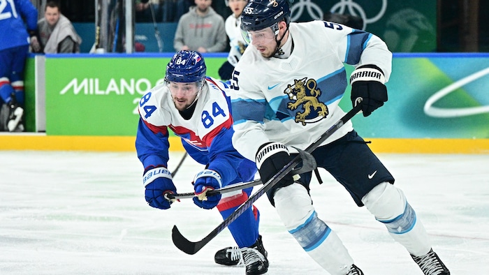 Deux hockeyeurs luttent pour prendre possession de la rondelle. 