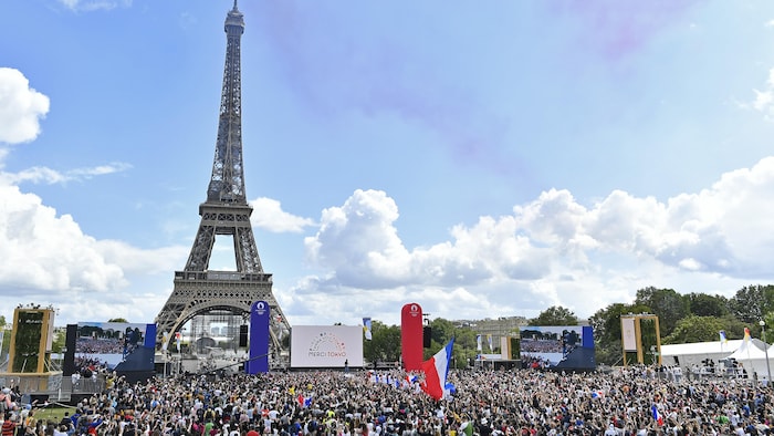 La foule est rassemblée devant la tour Eiffel.