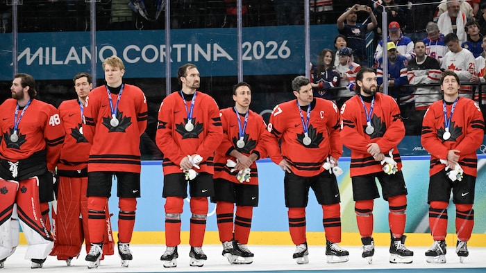 Les joueurs canadiens de hockey sur glace portent la médaille d'argent.