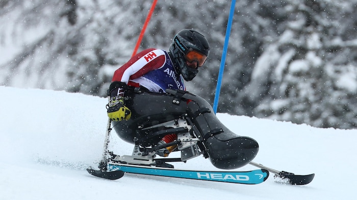 Un paraskieur effectue une descente de slalom.