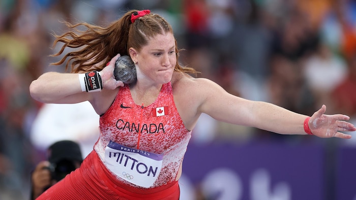 Sarah Mitton se prépare à lancer son poids qui est accoté dans son cou.