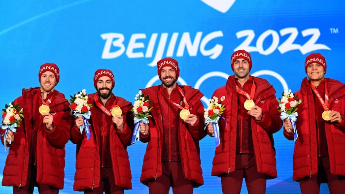 Les cinq patineurs, tout sourire, ont leur médaille à la main. 