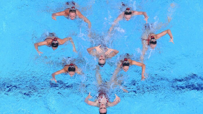 L'équipe canadienne de natation artistique forme un cœur dans la piscine.