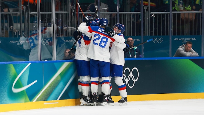 Des joueurs de l'équipe de hockey masculine de la Slovaquie, aux Jeux olympiques de Milan-Cortina, célèbrent un but.