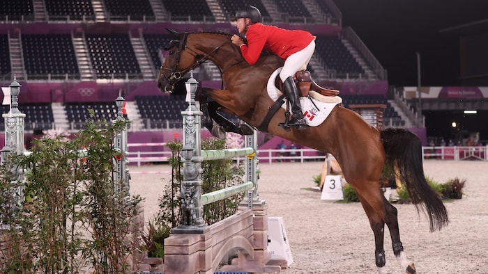 Le cavalier canadien Mario Deslauriers et son cheval franchissent un obstacle.