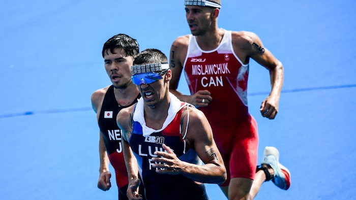 Un triahtlète canadien fait la course avec un Japonais et un Français aux Jeux de Tokyo.