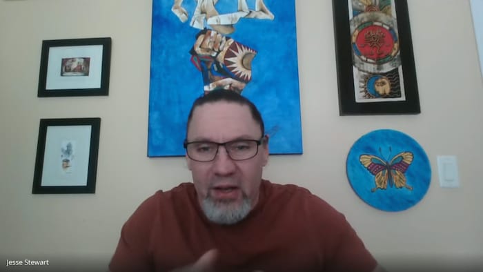 Un homme regarde sur l'écran d'un ordinateur lors d'une entrevue virtuelle, le 27 mars 2026.