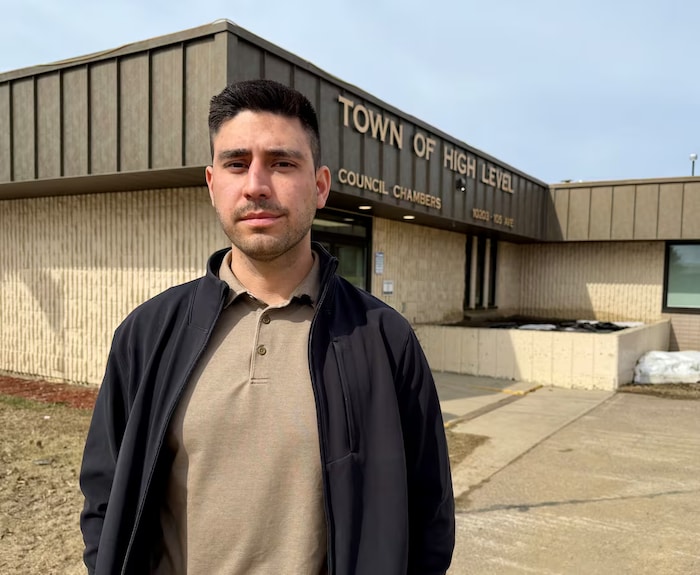 Une personne se tient devant l'hôtel de ville de High Level, en Alberta.