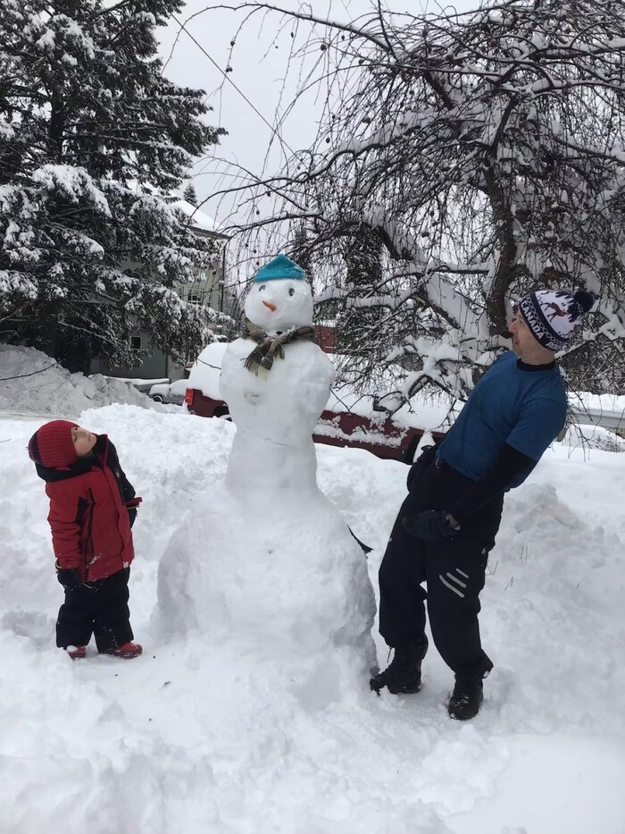 Kew, right, and his son, pictured at age five, build a snowman together in Rossland. (Submitted by Trevor Kew)