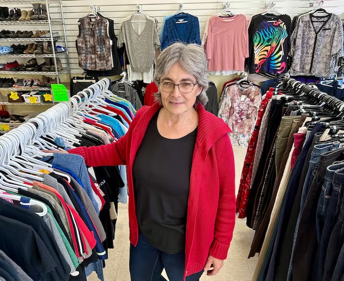 Une femme se tient entre les rayons de vêtements, dans un magasin de Beaumont, près d'Edmonton, en Alberta.