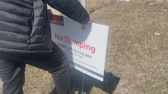 Un panneau indiquant aux habitants de Calgary qu'ils s'exposent à une amende pouvant atteindre 10 000 dollars en cas de dépôt de déchets dans un endroit non autorisé.