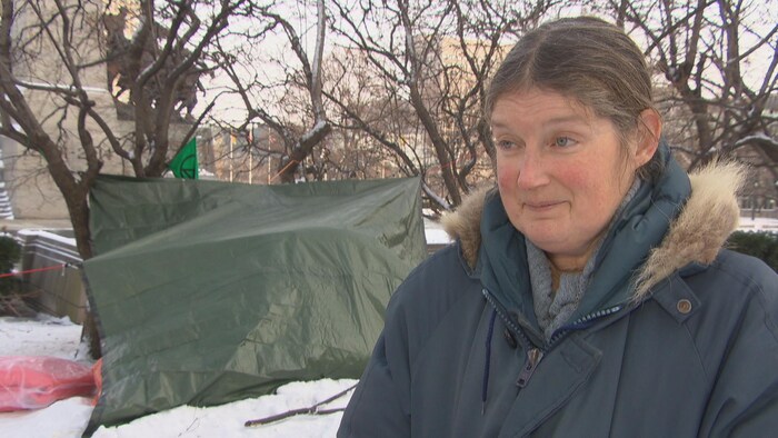 Une femme devant des tentes à Ottawa.