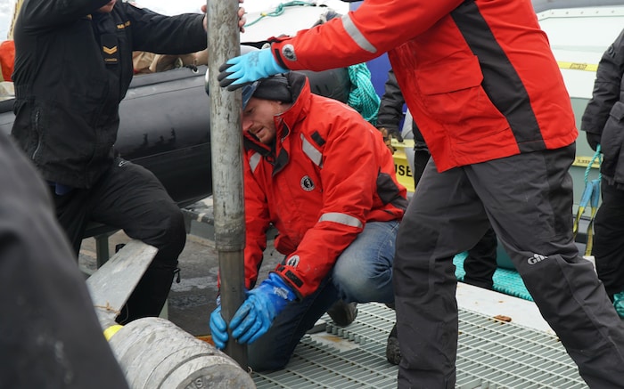 Alexandre Normandeau avec une carotte de sédiments.