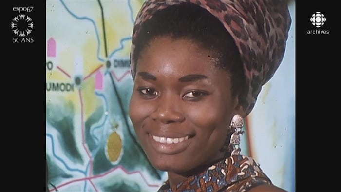Hôtesse du pavillon de la Côte d'Ivoire souriant à la caméra