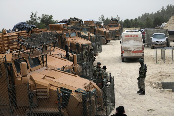 Des soldats turcs circulent parmi des camions de l'armée.