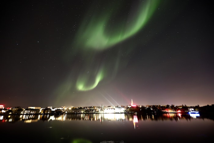 Une aurore boréale au-dessus de la capitale de l'Islande, Reykjavik. Plusieurs fois par année, la ville ferme ses lumières et incite les résidents à faire de même pour mieux voir les aurores boréales. 