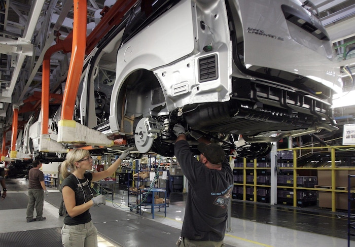 Un homme et une femme travaillent dans une usine d'assemblage du groupe Fiat Chrysler Automobiles à Windsor, en Ontario.