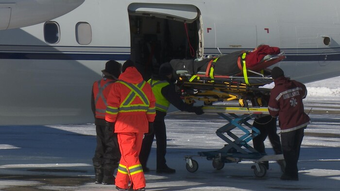 Préparation à l'mbarquement d'un patient dans un avion-ambulance
