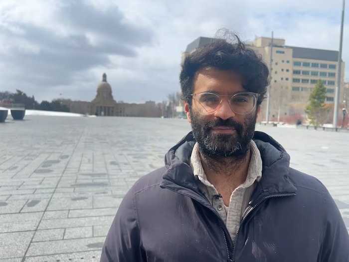 Une personne se trouve dans un lieu montrant l'Assemblée législative de l'Alberta en arrière-plan.