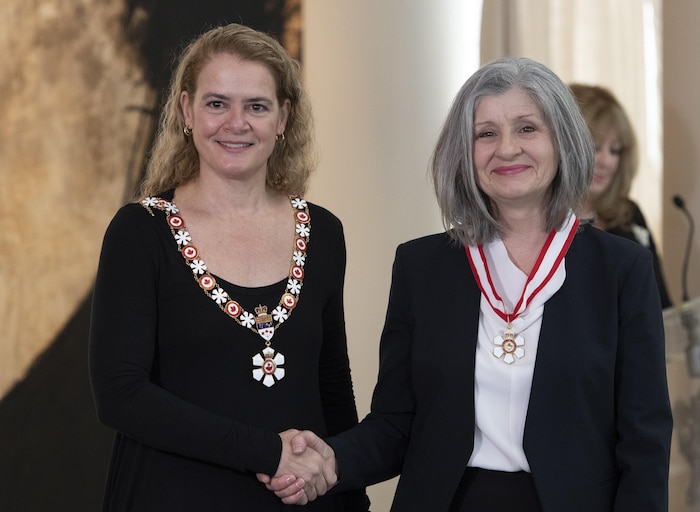 Deux femmes se serrent la main dans le cadre d'une cérémonie.