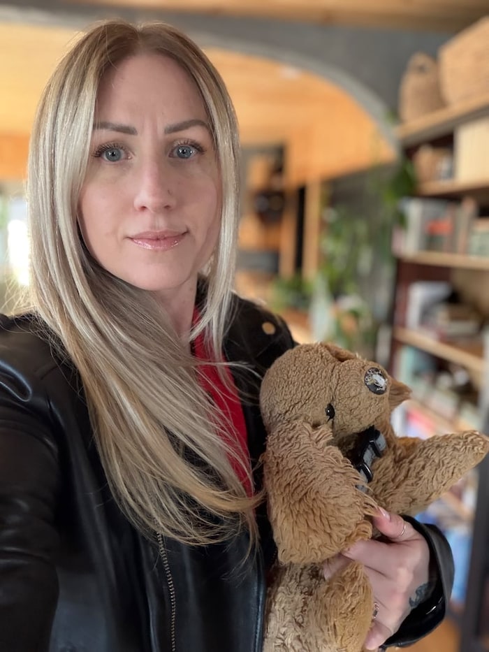 Bek MacIntosh tient une peluche dans ses bras.