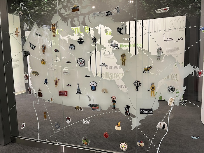 Une installation en verre fusionné sur laquelle on voit une représentation du Canada avec différents items.