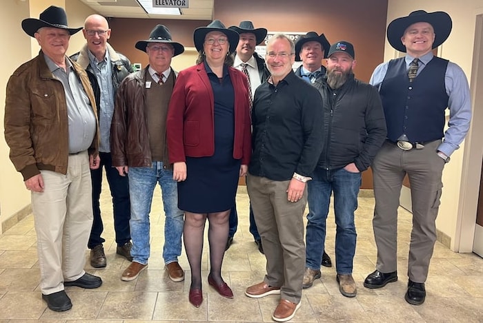 Une dizaines de personnes portent des chapeaux de cowboy noirs.