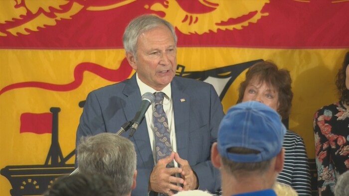 Blaine Higgs, devant un drapeau du Nouveau-Brunswick, s'adresse à ses militants. 