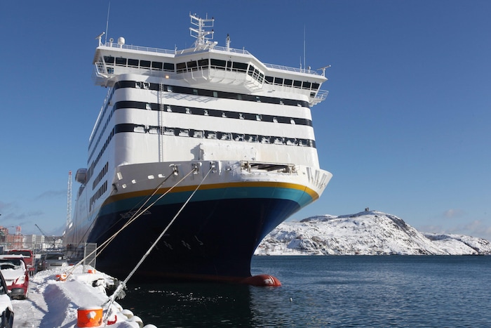 Le navire au port en hiver près d'une côte enneigée.