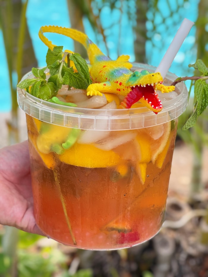 Une personne tient une limonade mojito au thé sucré glacé, de perles de tapioca et de grenouilles et vers à croquer.