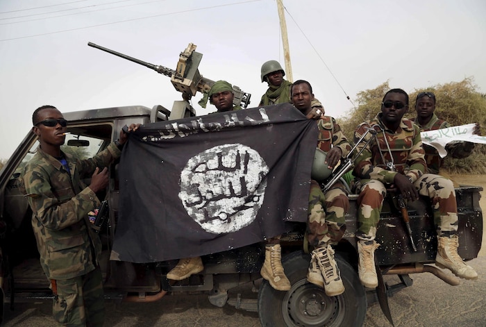 Des soldats nigérians tenant un drapeau saisi au groupe armé Boko Haram, le 18 mars 2015.