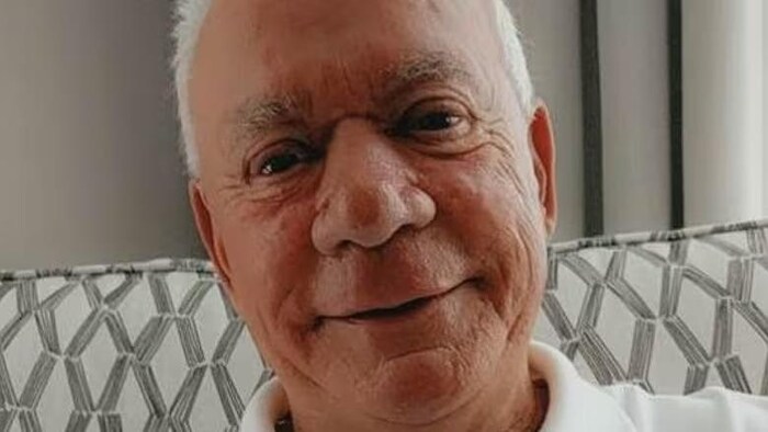 Un homme souriant, en portrait.