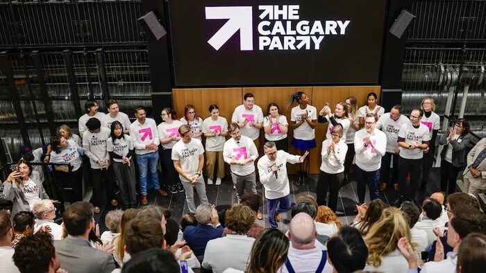 Des membres du parti politique municipal Calgary Party sont habillés en blanc lors d'un rassemblement partisan.