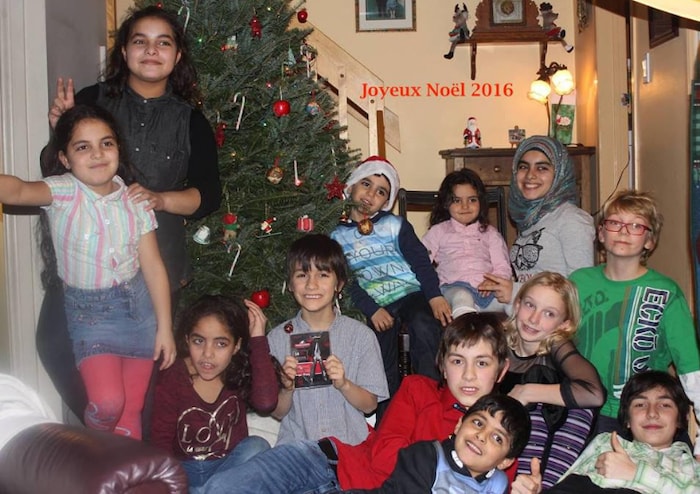 أطفال قرب شجرة عيد الميلاد داخل منزل.