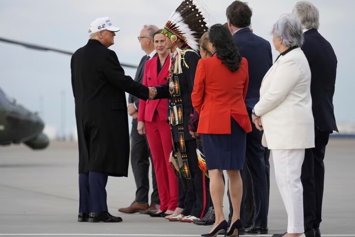 Le président américain Donald Trump saluant des dignitaires sur le tarmac de l'aéroport de Calgary, où il a atterri le 15 juin 2025 pour participer au Sommet du G7 à Kananaskis.