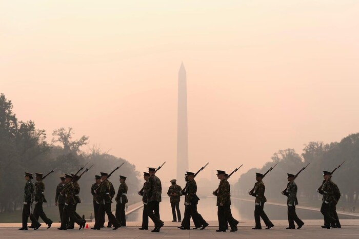With the Washington Monument in the background and a thick layer of smoke, the Marine Corps Color Guard rehearses on Thursday, June 8, 2023, in Washington, D.C.