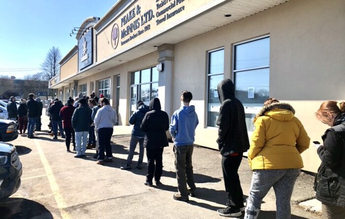 Clients en ligne dehors devant un magasin de cannabis.