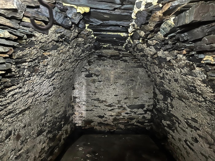 Une chambre souterraine en pierre avec un plafond en voûte.