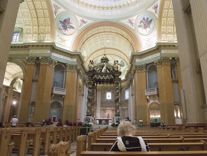 Une fidèle est assise sur un banc d'église.