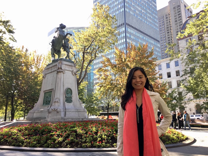 Cathy Wong debout près d'une statue dans un parc.