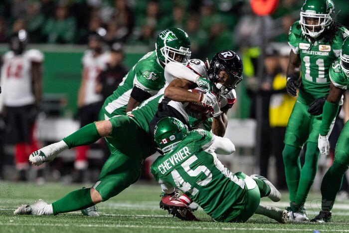 trois joueurs de football en action lors d'un match. le joueur avec le numéro 45 (Alexandre Chevrier) est sur le sol et un autre joueur est en train d'attraper le ballon au-dessus de lui.
