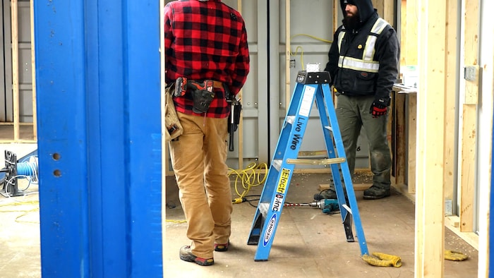 Des ouvriers sur le chantier d'une maison conteneur à Edmonton