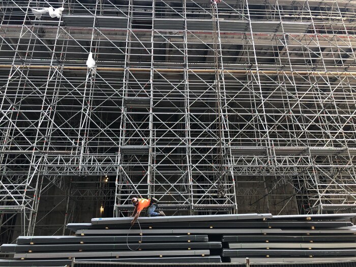 Un ouvrier décharge du matériel sur un chantier de construction d'un bâtiment à Toronto.