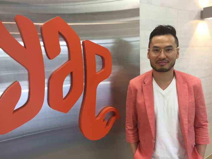 Will Lee devant le logo de son entreprise technologique, YAP.